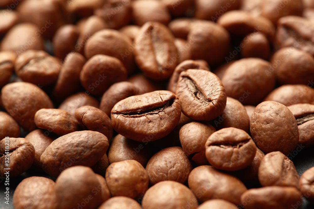 Brown roasted coffee beans on dark background. Espresso dark, aroma, black caffeine drink. Closeup isolated energy mocha, cappuccino ingredient. Brown roasted coffee beans on dark background. Espresso dark, aroma, black caffeine drink. Closeup isolated energy mocha, cappuccino ingredient.