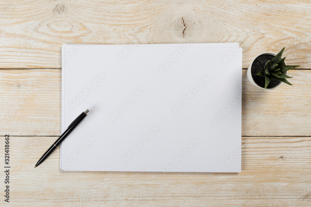 A4 white paper with pen on wooden background. Blank branding template. Photo blank form. Layout