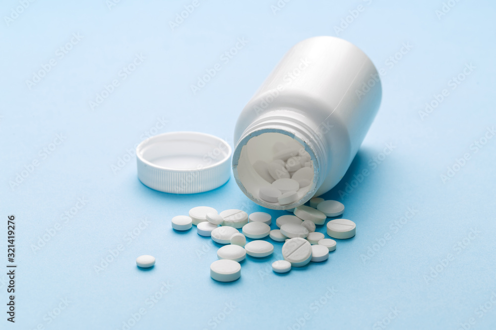 bottle with medicines on a blue table. flat lay for text or logo.Global healthcare concept. Antibiotics drug resistance. Antimicrobial capsule tablets. Pharmaceutical industry. bottle with medicines on a blue table. flat lay for text or logo.Global healthcare concept. Antibiotics drug resistance. Antimicrobial capsule tablets. Pharmaceutical industry.