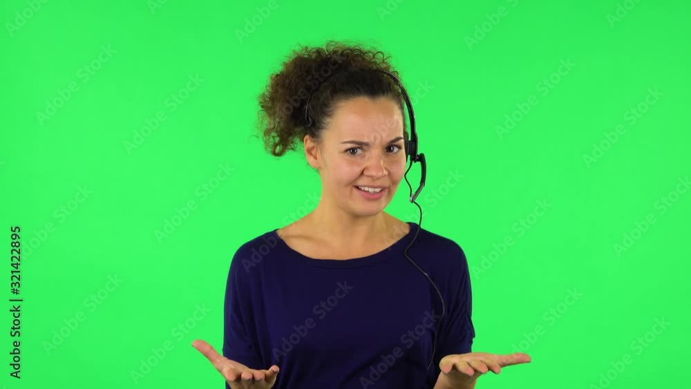 Portrait of curly woman talking on headphones, call center. Green screen Portrait of curly woman talking on headphones, call center. Green screen
