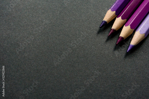 Purple colored pencils on a black background