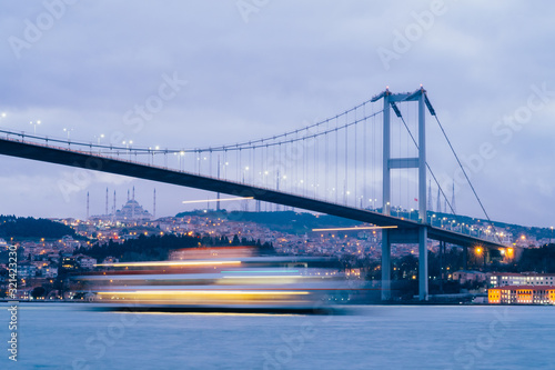 Sunset or Dusk over the First Bosporus Bridge Crossing the Bosphorus or Bosporus Straits Istanbul Turkey. Büyük Çamlıca Camii Mosque and Beylerbeyi Palace are visible .