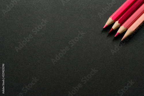 Pink colored pencils on a black background