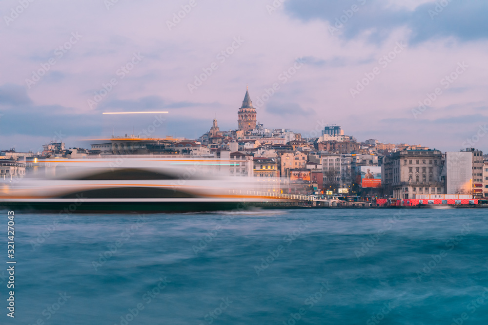 Naklejka premium Istanbul, Turkey - Jan 15, 2020: Galata Tower with Ferry Boat in Golden Horn , Istanbul, Turkey,