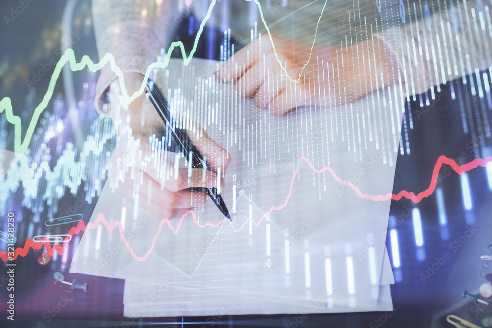 Hand taking notes in notepad. Forex chart holograms in front. Concept of research. Multi exposure Hand taking notes in notepad. Forex chart holograms in front. Concept of research. Multi exposure