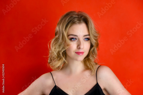 Wallpaper Mural The concept of cosmetics, fashion and style. Glamorous beauty front view portrait of a pretty model with blond hair with great makeup and a beautiful hairstyle on a red background in the studio. Torontodigital.ca