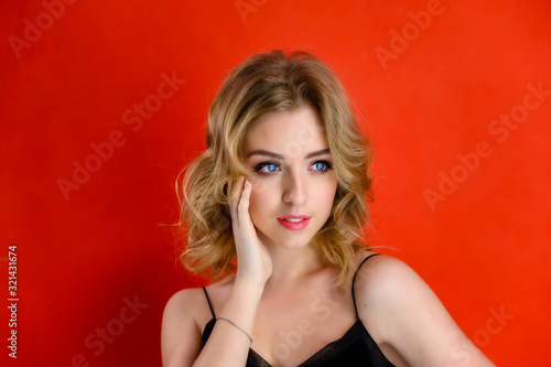 Wallpaper Mural The concept of cosmetics, fashion and style. Glamorous beauty front view portrait of a pretty model with blond hair with great makeup and a beautiful hairstyle on a red background in the studio. Torontodigital.ca