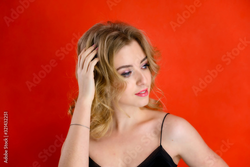 Wallpaper Mural Glamorous beauty front view portrait of a pretty model with blond hair with great makeup and a beautiful hairstyle on a red background in the studio. The concept of cosmetics, fashion and style. Torontodigital.ca