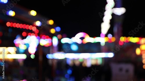 Blurry colorful blinking lights of fairground at night photo