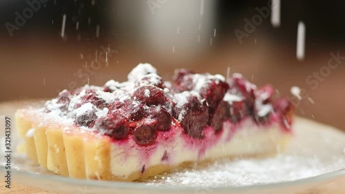 Sprinkle sugar powder on rotating cheesecake slow motion. Close up shot on 4k RED camera photo