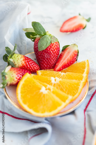 Slices of orange with strawberries on a plate