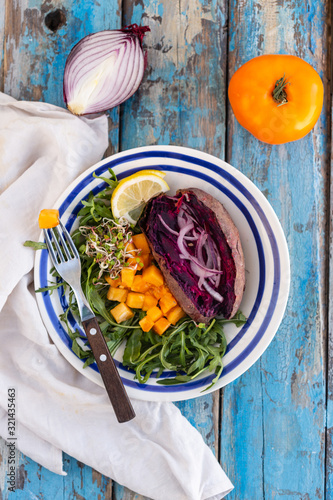 Healthy oil free plant based dinner with sweet potato, greens and yellow tomato