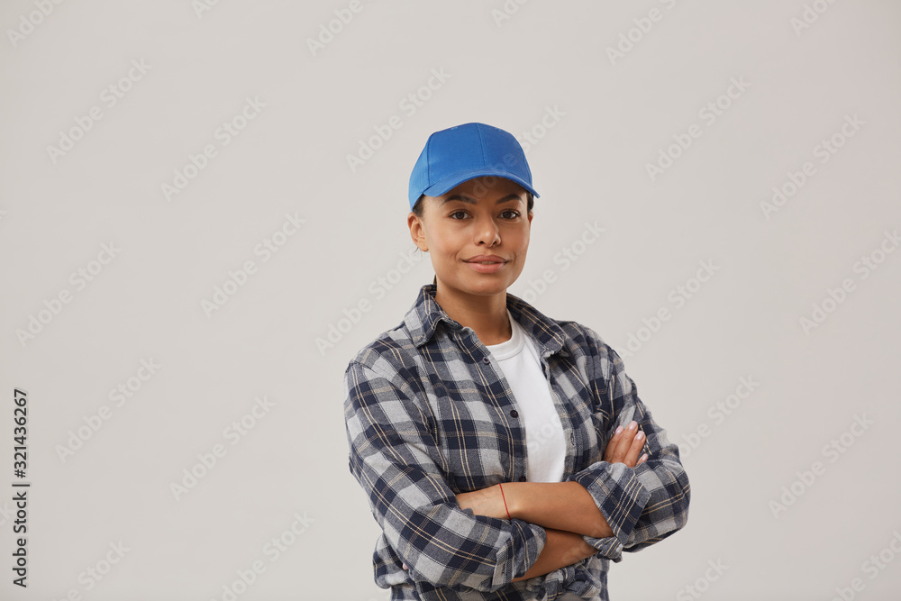 Waist up portrait of beautiful female worker smiling at camera while posing confidently against white background standing with arms crossed, copy space
