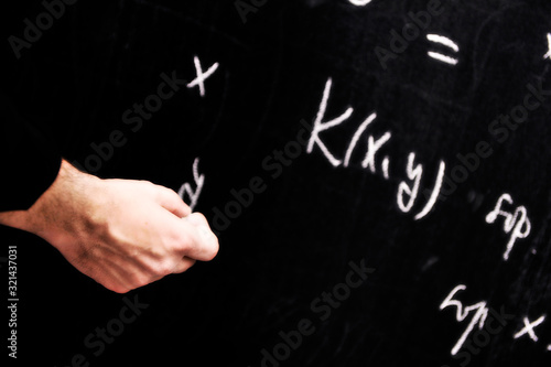 Teacher writing a mathematical equation on a  screen