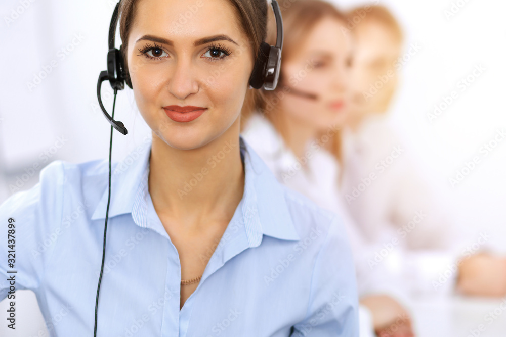 Call center. Focus on beautiful business woman using headset in sunny office Call center. Focus on beautiful business woman using headset in sunny office