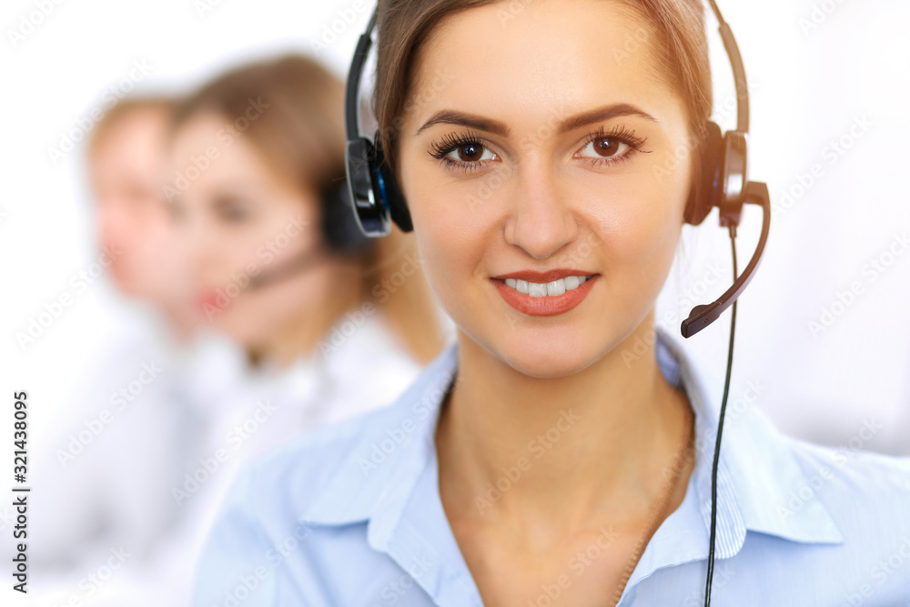 Call center. Focus on beautiful business woman using headset in sunny office Call center. Focus on beautiful business woman using headset in sunny office