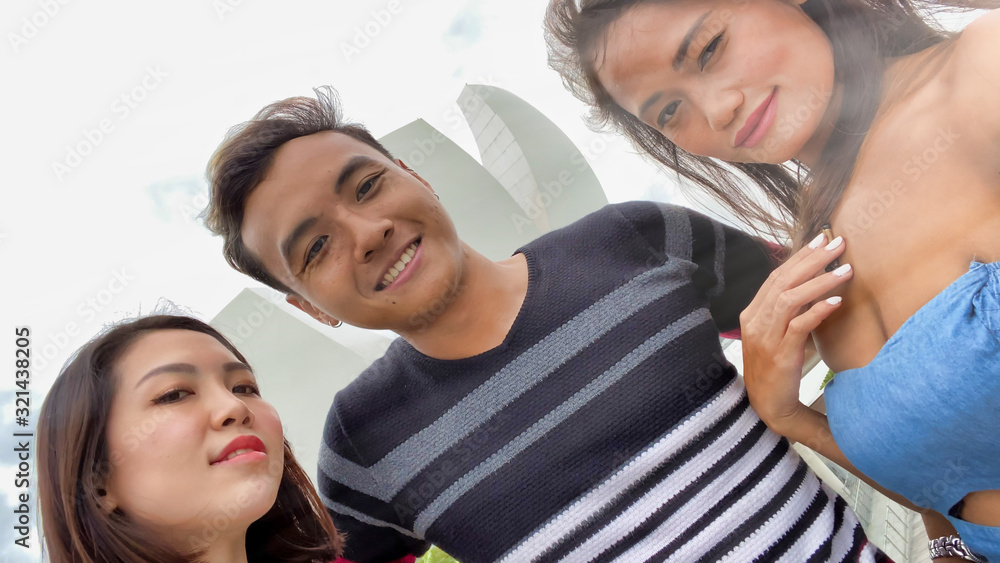 Three asian friends enjoying outdoor city life, taking selfies. Friendship and holiday concept Three asian friends enjoying outdoor city life, taking selfies. Friendship and holiday concept