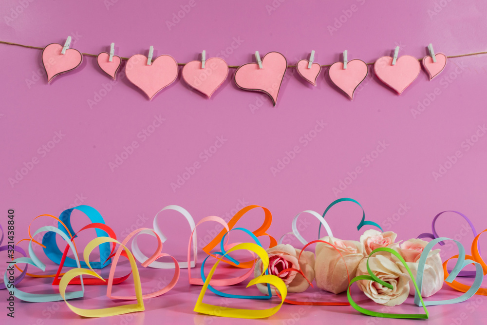 multicolored Love hearts and roses on pink background.