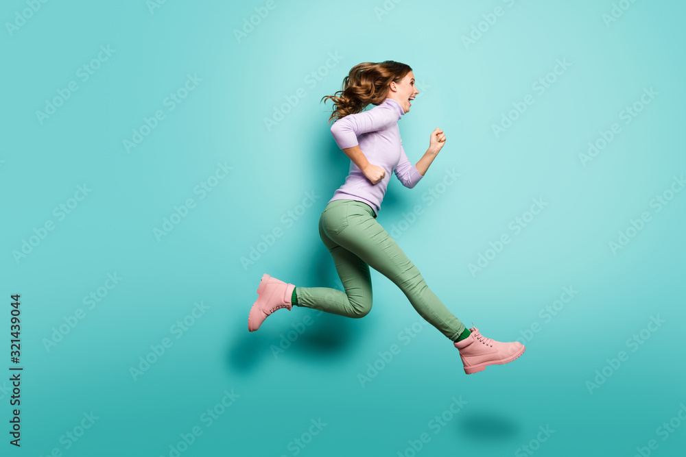 Full length profile photo of pretty crazy lady jumping high up speed rushing black friday shopping center wear lilac jumper green pants shoes isolated teal pastel color background