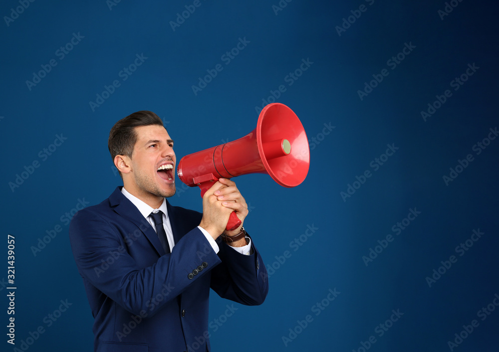 Handsome man with megaphone on blue background Handsome man with megaphone on blue background