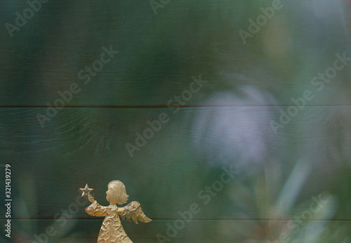 Christmas card with a golden angel in front of a green background with colourful christmas reflections © stock mp
