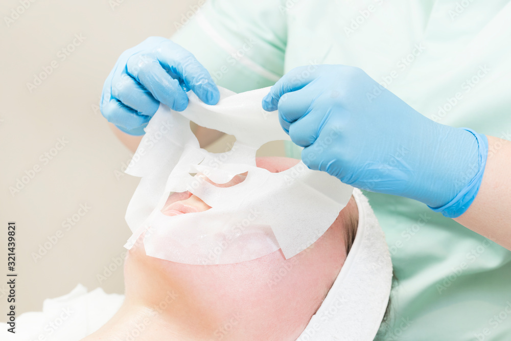 Fototapeta premium Procedure female cosmetic mask and chistak face in a beauty salon.