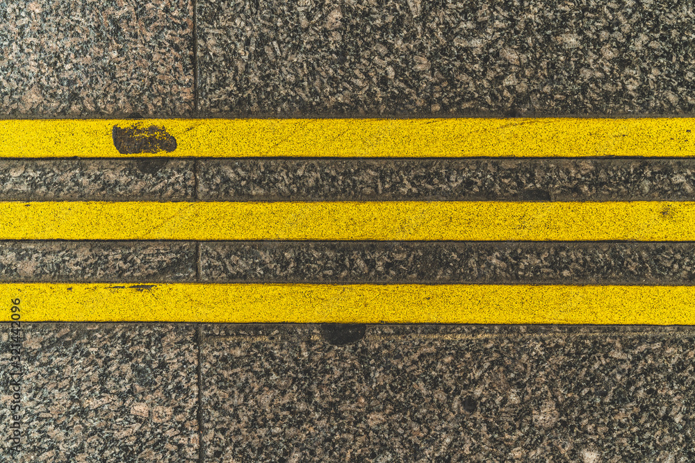 Fototapeta premium Three yellow stripes on the pavement. Restrictive lines