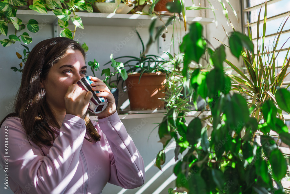 Young white woman drinking coffee on a balcony Young white woman drinking coffee on a balcony