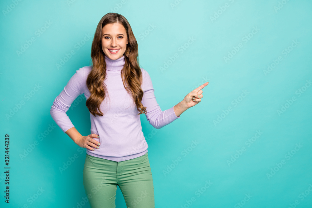 Photo of amazing pretty lady indicate finger empty space advising novelty product sale low prices wear purple lilac pullover green trousers isolated pastel teal color background Photo of amazing pretty lady indicate finger empty space advising novelty product sale low prices wear purple lilac pullover green trousers isolated pastel teal color background