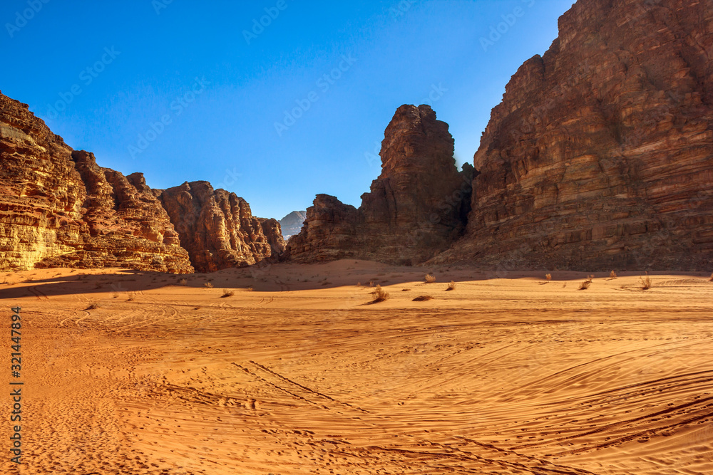 Naklejka premium Wadi Rum Desert and Valley of the Moon at sunset in southern Jordan. Popular tourist destination for spectacular sandstone and granite rock. Aerial view landscape.