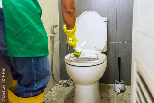 Cuadro en lienzo closeup photo of hand brushing a dirty toilet seat