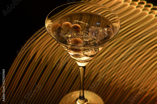 Long exposure martini glass with ice and olives