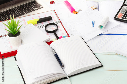Work with documents. Notebook, pen, laptop, calculator, financial documents on the table. Light background