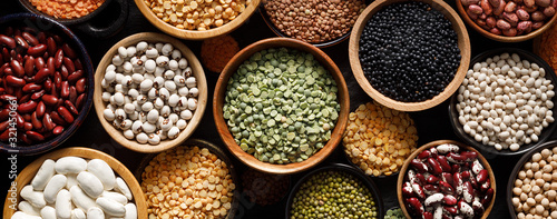 Foto Legumes, a set consisting of different types of beans, lentils and peas on a black background, top view, close up