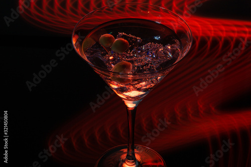 Long exposure martini glass with ice and olives