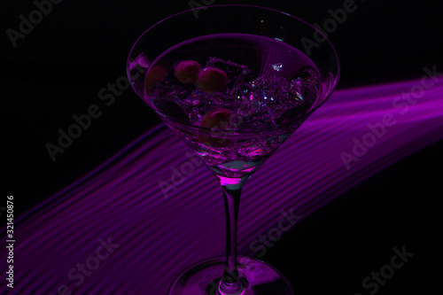 Long exposure martini glass with ice and olives