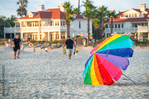 Colourful beach umbrella at sunset with tourists. Holiday concept © jovannig