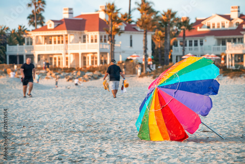 Colourful beach umbrella at sunset with tourists. Holiday concept
