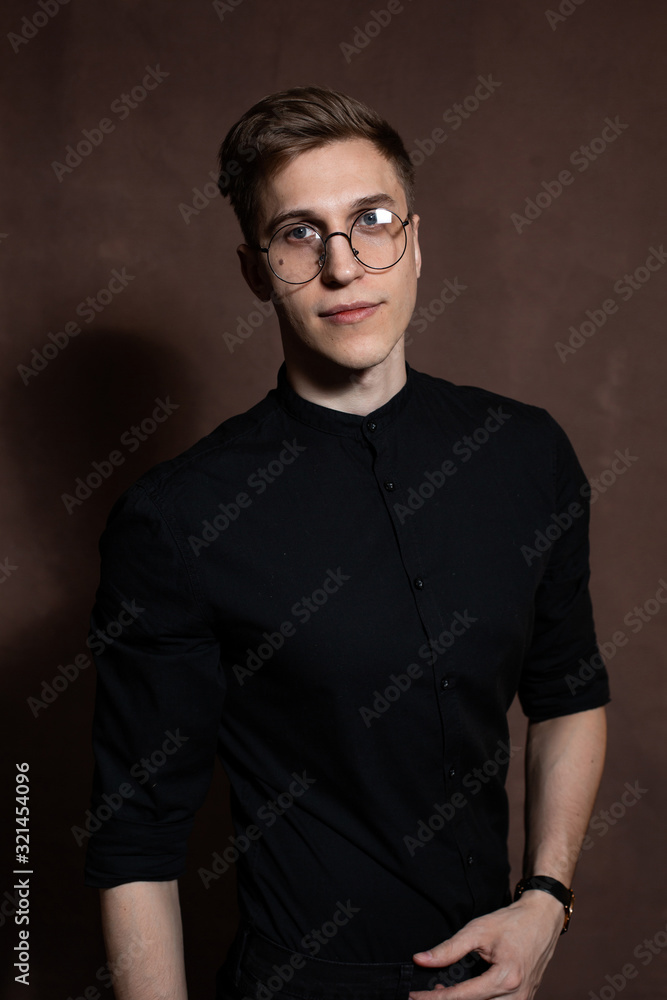 Obraz premium Man in round glasses and a black shirt.