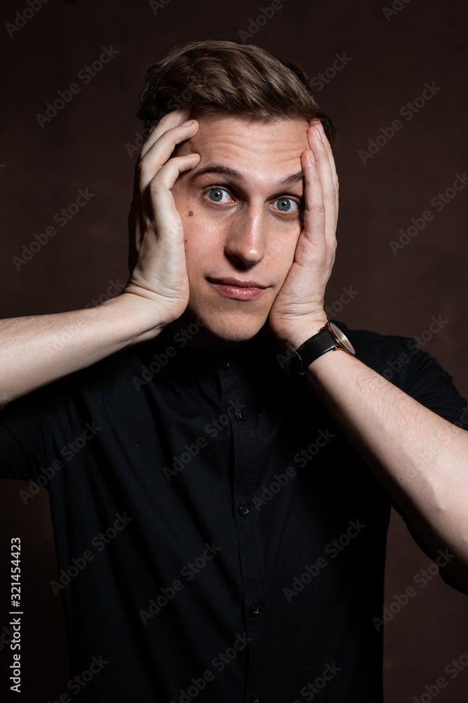 A man in round glasses and a black shirt is grimacing A man in round glasses and a black shirt is grimacing