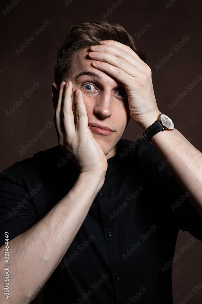 A man in round glasses and a black shirt is grimacing A man in round glasses and a black shirt is grimacing