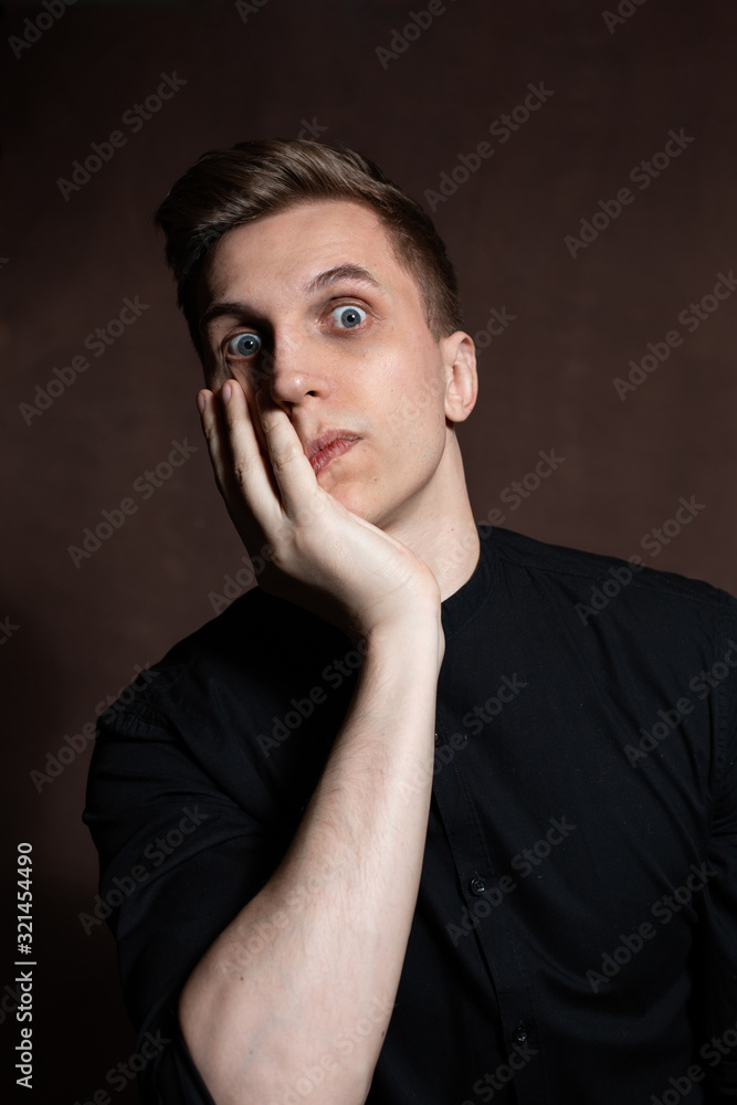 A man in round glasses and a black shirt is grimacing A man in round glasses and a black shirt is grimacing