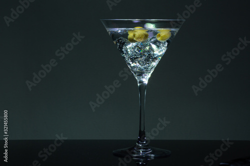 Long exposure martini glass with ice and olives