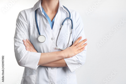 Doctor with stethoscope on white background, closeup. Medical service