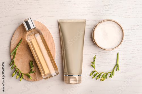 Flat lay composition with cosmetic products on white wooden table