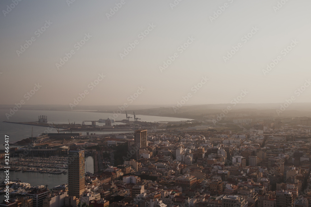 Alicante city and port panorama in haze at sunset in September 