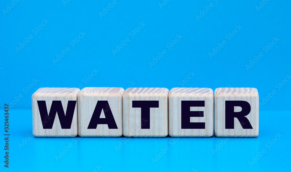 concept word water on wooden cubes on a blue background concept word water on wooden cubes on a blue background