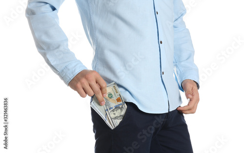 Man putting bribe money into pocket on white background, closeup