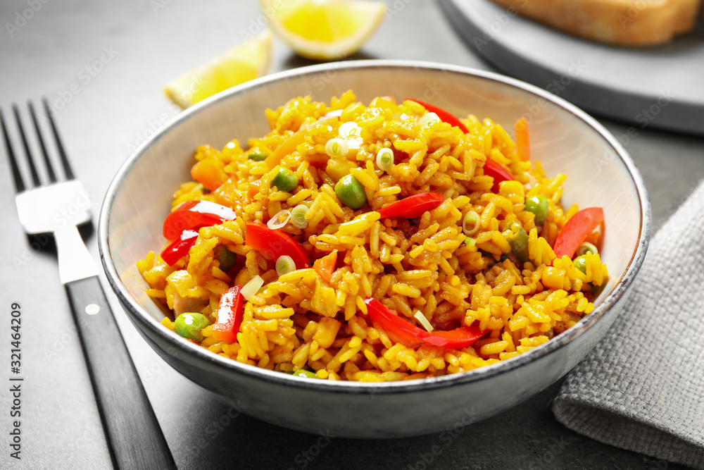 Delicious rice pilaf with vegetables on grey table Delicious rice pilaf with vegetables on grey table