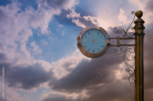 Street clock on sky background. Classic style streeet clock. 12 o'clock. photo